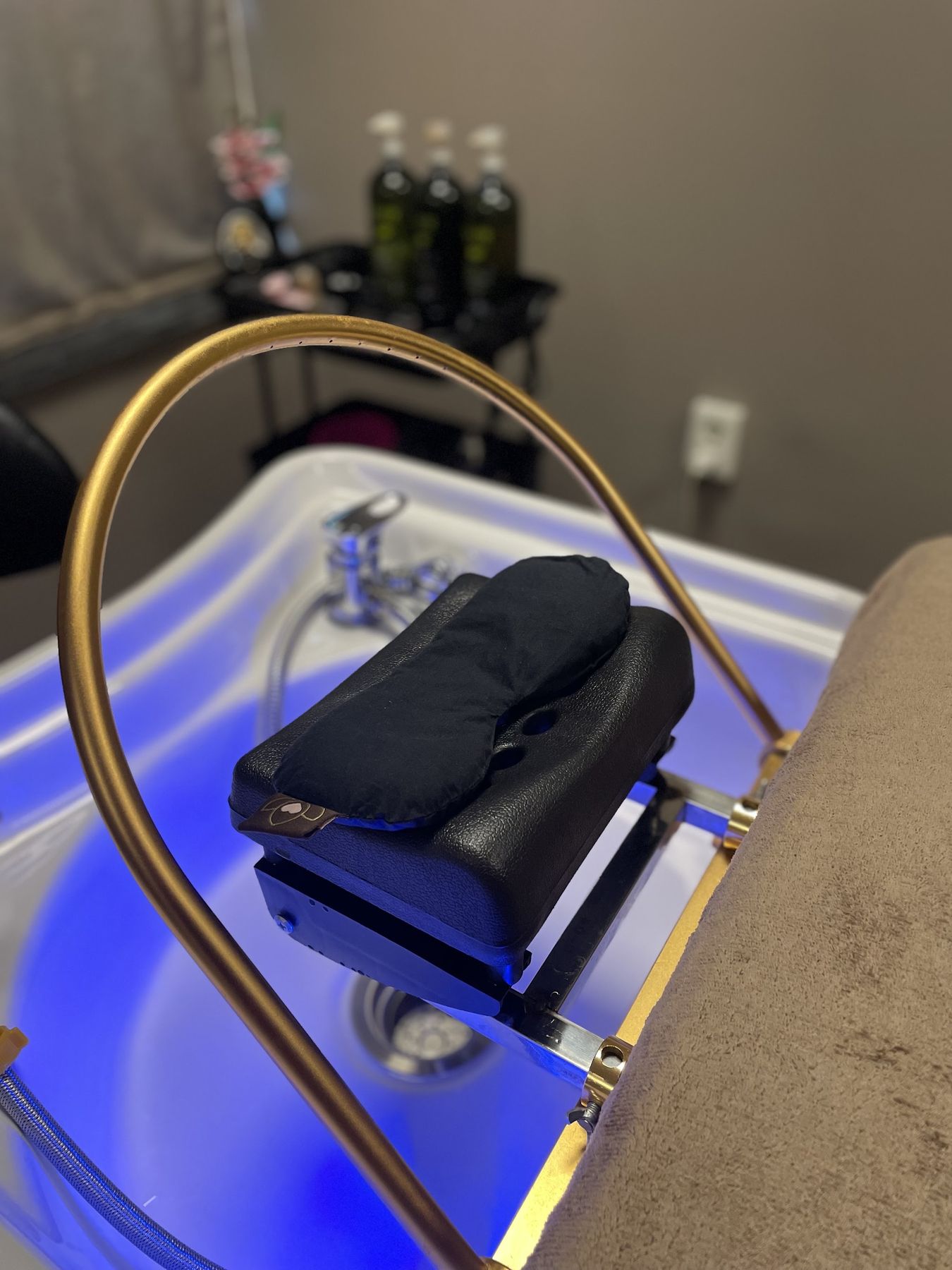 De nekleuning van de headspa met een oogmasker klaar, de waskom blauw verlicht